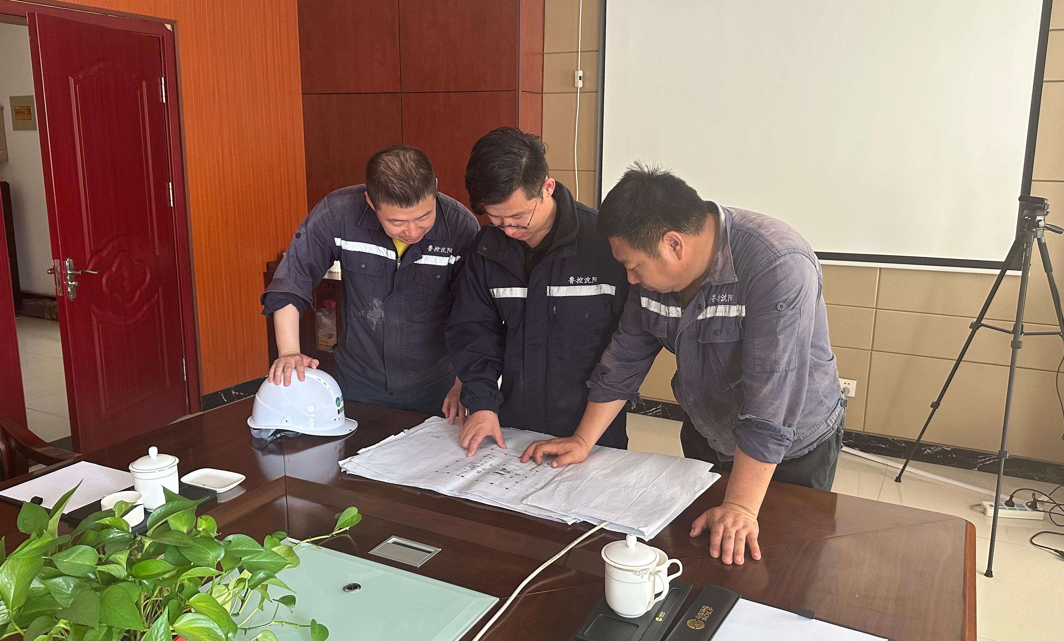 孫茂(中間)與同事研究篩分機(jī)調(diào)整方案.jpg